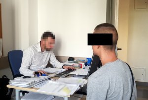 Policjant przedstawia zarzuty podejrzanemu