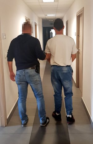 Policjant prowadzący podejrzanego na przesłuchanie