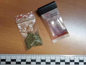 Zdjęcie przedstawia woreczek foliowy z suszem koloru zielonego oraz narkotester potwierdzający, że zabezpieczony susz to marihuana.