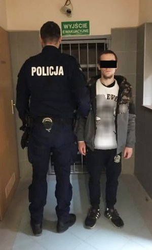 Zdjęcie przedstawia zatrzymanego 20-latka stojącego przodem do obiektywu oraz umundurowanego policjanta.