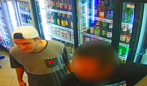 mężczyzna w białej czapeczce założonej daszkiem do tyłu, koszulce niebiesko szarej, krótkich żółtych spodenkach i czerwonych butach adidas
