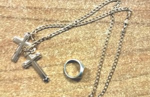 zabezpieczona biżuteria w postaci łańcuszka z dwoma krzyżami oraz sygnetu z bursztynowym okiem