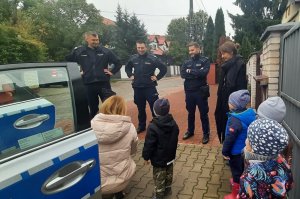 Wilanowscy dzielnicowi rozmawiają z dziećmi Przedszkola Zielony Latawiec na warszawskim Wilanowie, na czym tak naprawdę polega ich praca. Na zdjęciu dzieci w radiowozach oraz trzej umundurowani dzielnicowi - sierżanci sztabowi Bartosz Wysocki, Kamil Tkaczyk i Łukasz Wężowski.