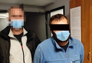 Po lewej stronie stoi nieumundurowany policjant z wydziału wywiadowczo patrolowego KP Warszawa Ursynów. Z prawej strony zatrzymany mężczyzna, podejrzany o posiadania środków odurzających.