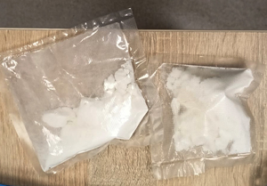 Dwa foliowe przeźroczyste woreczki z białym proszkiem w postaci kokainy.