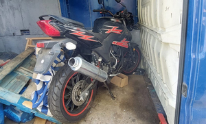 Czarny motocykl a elementami czerwonych zygzaków na ramie. Motocykl jest umieszczony w skrzyni załadunkowej w furgonetce