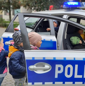 Na zdjęciach umundurowani policjanci w klasie rozmawiają z przedszkolakami ucząc ich podstawowych zasad bezpieczeństwa.