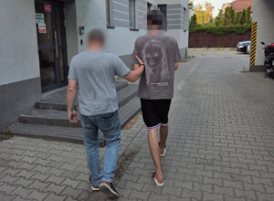 Policjant prowadzi zatrzymanego