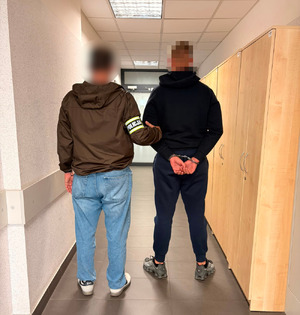 Nieumundurowany policjant prowadzi zatrzymanego