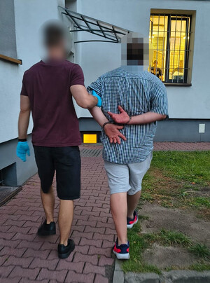 Policjant prowadzi zatrzymanego