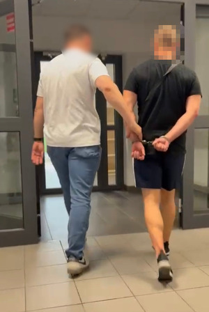 Policjant prowadzi zatrzymanego